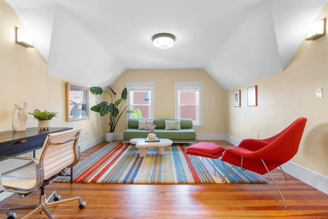 interior space featuring baseboards, vaulted ceiling, and wood finished floors