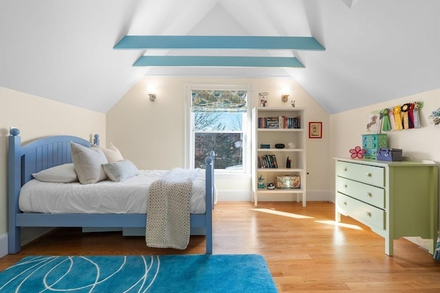 bedroom with lofted ceiling with beams, baseboards, and wood finished floors