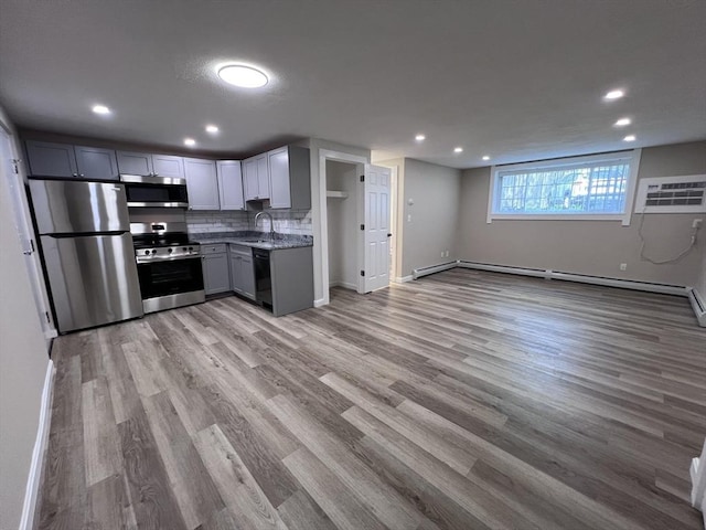 12 Woodland St Unit 12, Everett, MA 02149 - kitchen featuring stainless steel appliances, light wood-type flooring, recessed lighting, open floor plan, and baseboards