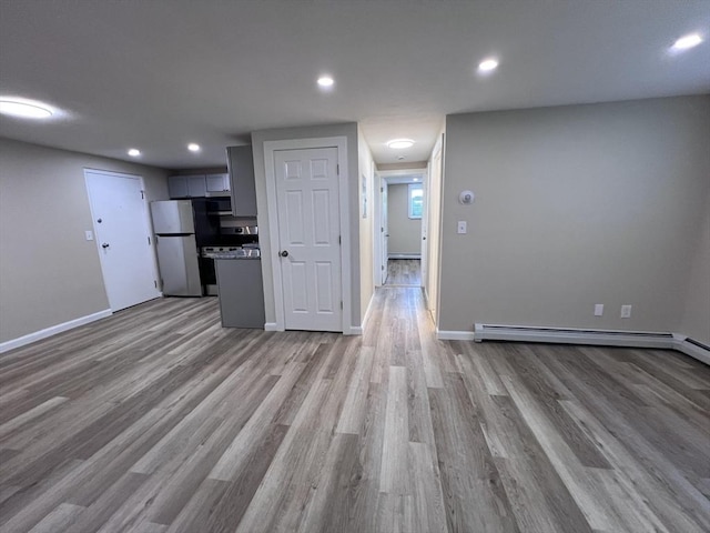 12 Woodland St Unit 12, Everett, MA 02149 - kitchen featuring freestanding refrigerator, open floor plan, gray cabinets, light wood finished floors, and baseboards