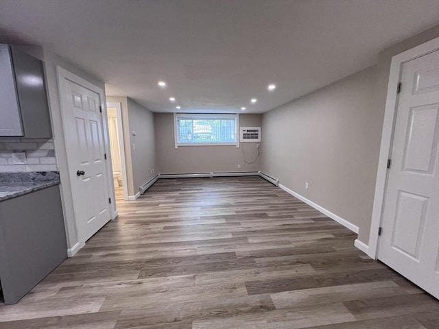 12 Woodland St Unit 12, Everett, MA 02149 - basement with wood finished floors, recessed lighting, a baseboard heating unit, baseboards, and a wall unit AC