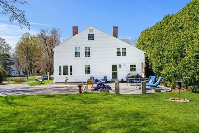 228 Main St, Groton, MA 01450 - rear view of house featuring a patio, a chimney, and a lawn