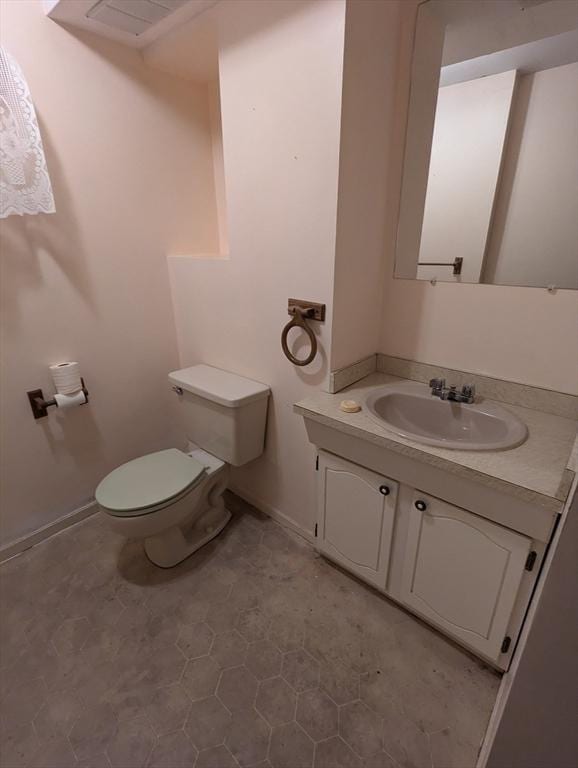 bathroom with vanity, toilet, and baseboards