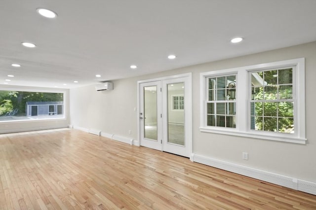 unfurnished living room featuring baseboards, an AC wall unit, wood finished floors, and recessed lighting