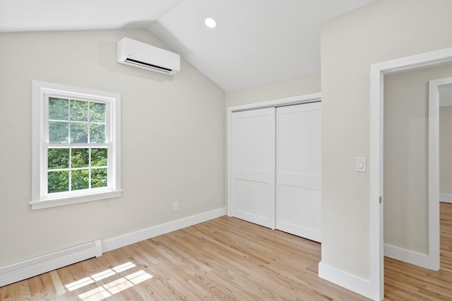 unfurnished bedroom with baseboards, vaulted ceiling, an AC wall unit, light wood-type flooring, and a baseboard heating unit