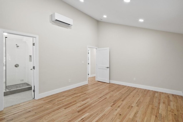 spare room with baseboards, recessed lighting, a wall unit AC, and light wood-style floors