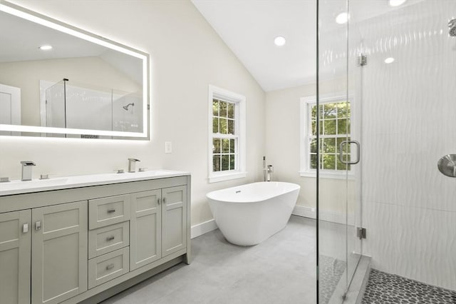 bathroom with lofted ceiling, double vanity, a stall shower, and a sink