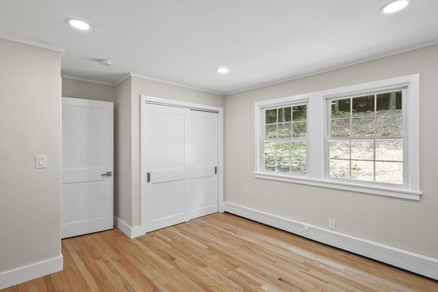 unfurnished bedroom featuring crown molding, recessed lighting, baseboard heating, light wood-type flooring, and baseboards