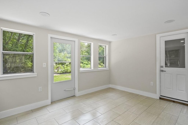 doorway to outside featuring plenty of natural light and baseboards