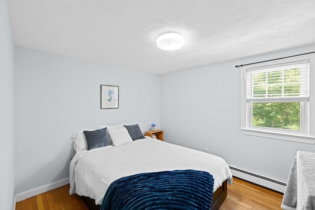 59 First Parish Rd, Norwell, MA 02061 - bedroom featuring a baseboard radiator, wood finished floors, and a textured ceiling