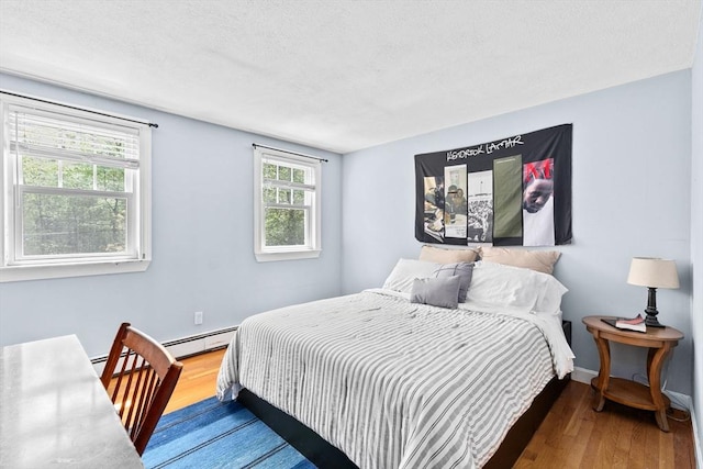 59 First Parish Rd, Norwell, MA 02061 - bedroom with wood finished floors, a baseboard heating unit, and a textured ceiling