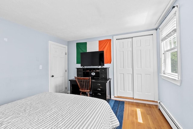 59 First Parish Rd, Norwell, MA 02061 - bedroom with a baseboard heating unit, wood finished floors, and a closet