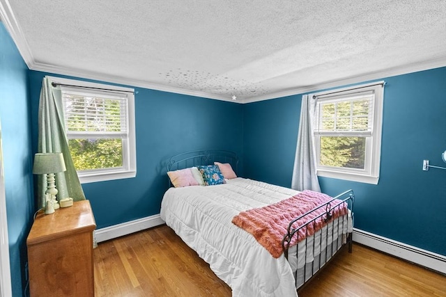 59 First Parish Rd, Norwell, MA 02061 - bedroom with a baseboard heating unit, a textured ceiling, wood finished floors, and ornamental molding