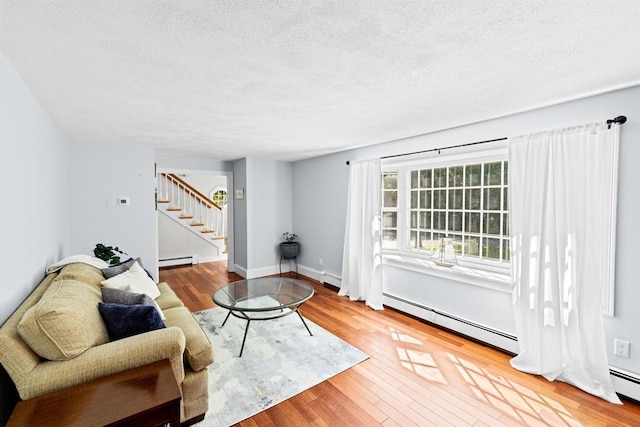 59 First Parish Rd, Norwell, MA 02061 - living room featuring a baseboard heating unit, stairs, a textured ceiling, and wood finished floors