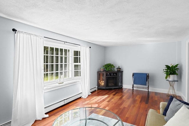 59 First Parish Rd, Norwell, MA 02061 - living area featuring a baseboard heating unit, a textured ceiling, baseboard heating, and wood finished floors