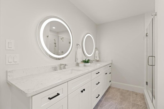 bathroom featuring a shower stall, double vanity, and baseboards