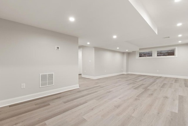 finished basement with recessed lighting, light wood-style floors, and baseboards