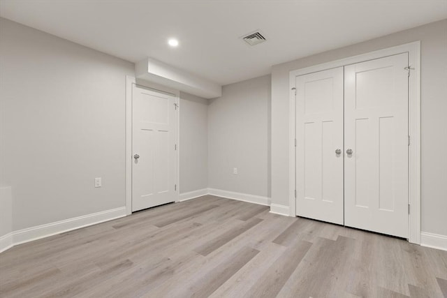 finished basement featuring light wood-style floors, baseboards, and recessed lighting