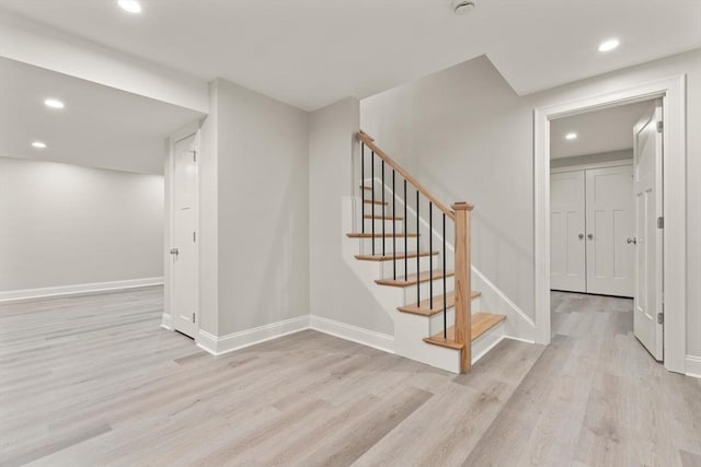stairway featuring wood finished floors, recessed lighting, and baseboards