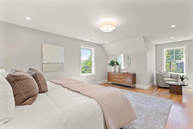 bedroom featuring multiple windows, wood finished floors, baseboards, recessed lighting, and vaulted ceiling