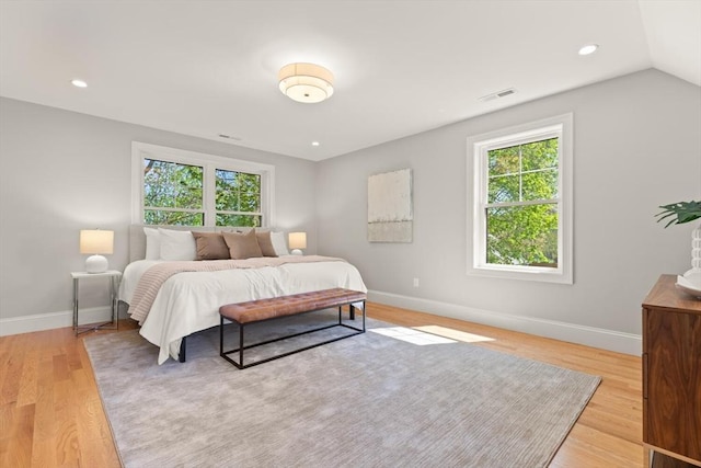bedroom with multiple windows, light wood-style flooring, baseboards, and recessed lighting