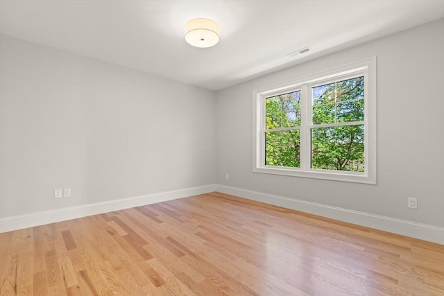 spare room featuring light wood-style floors and baseboards