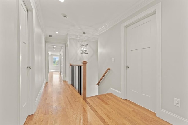 corridor with an upstairs landing, crown molding, light wood-type flooring, baseboards, and recessed lighting