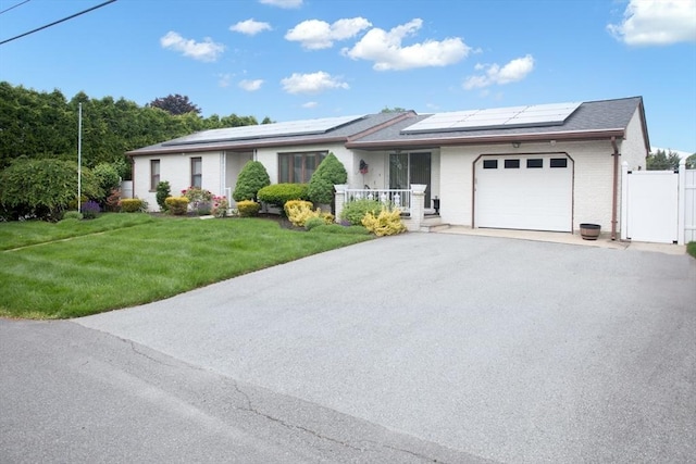 136 Maryland Ave, Somerset, MA 02726 - single story home with a garage, a gate, asphalt driveway, solar panels, and brick siding