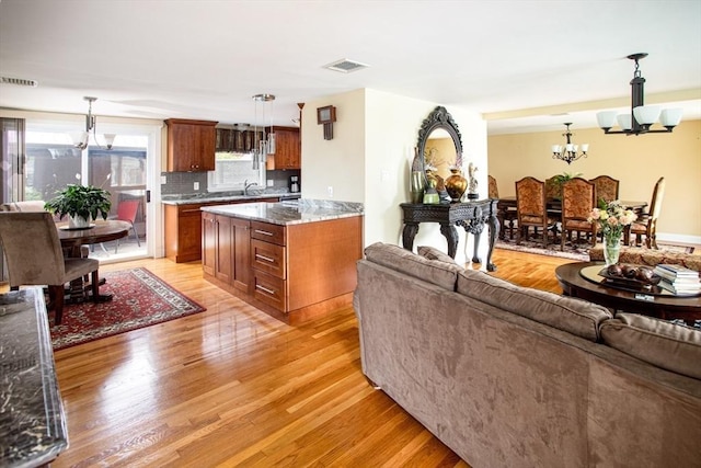 136 Maryland Ave, Somerset, MA 02726 - living room featuring a chandelier and light wood-style flooring