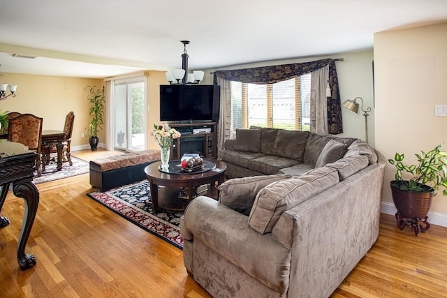 136 Maryland Ave, Somerset, MA 02726 - living area with a chandelier, light wood-style floors, and baseboards