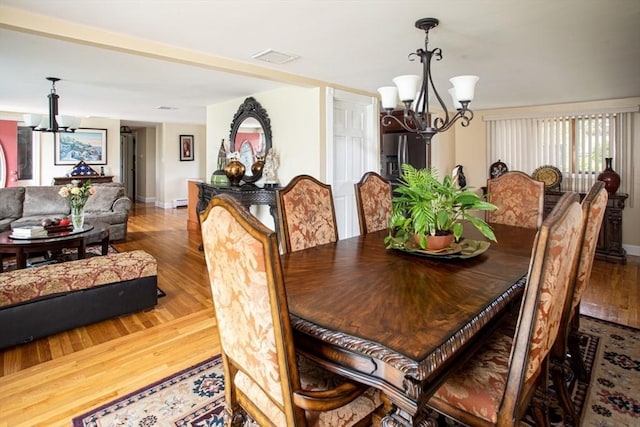 136 Maryland Ave, Somerset, MA 02726 - dining area with a chandelier, wood finished floors, and baseboards