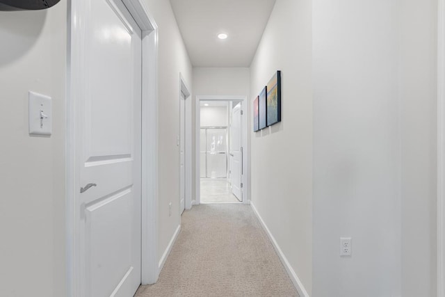 hallway featuring baseboards, light carpet, and recessed lighting