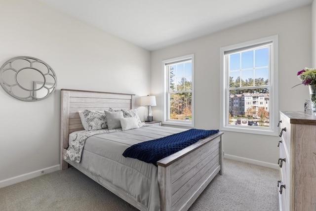 bedroom featuring baseboards and light carpet