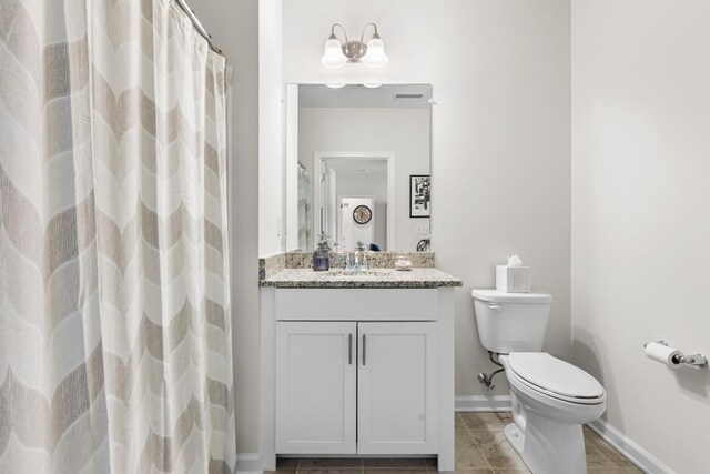 full bath with a notable chandelier, tile patterned flooring, vanity, toilet, and baseboards