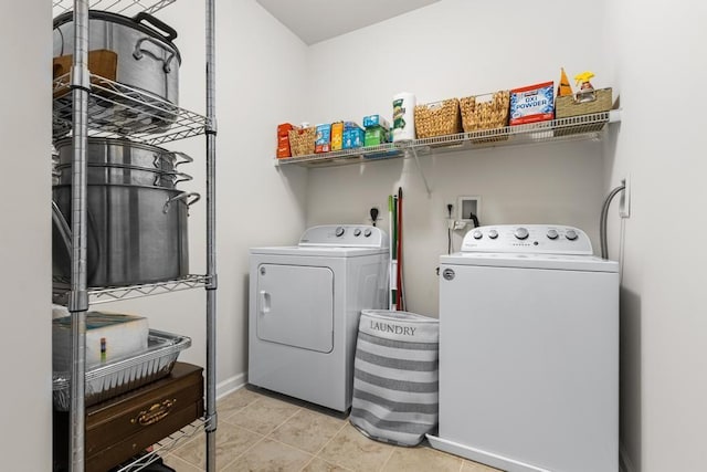 laundry room with laundry area, washer and clothes dryer, baseboards, and tile patterned floors