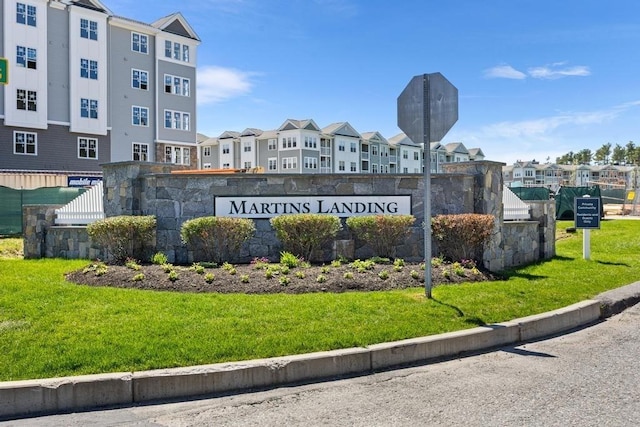 community sign featuring a residential view and a lawn