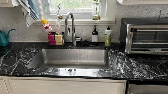 135-137 Summer St, Waltham, MA 02452 - kitchen view of a sink, tasteful backsplash, white cabinetry, and dark stone counters