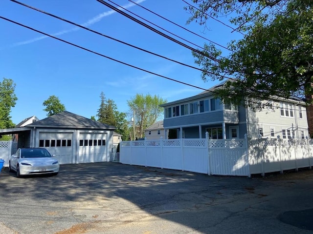 135-137 Summer St, Waltham, MA 02452 - view of side of property with fence, a detached garage, and an outbuilding