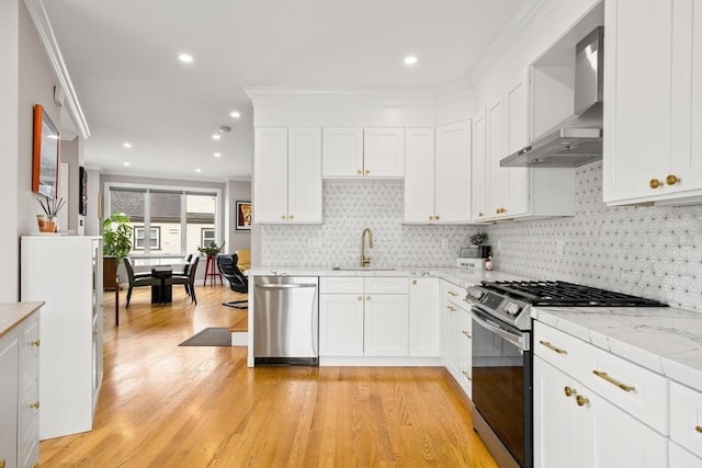 kitchen with range with gas cooktop, stainless steel dishwasher, wall chimney range hood, a sink, and light wood-type flooring