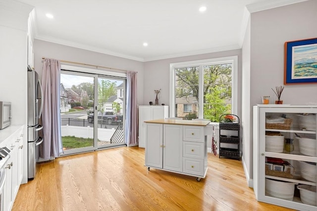 doorway to outside with light wood finished floors, healthy amount of natural light, crown molding, and recessed lighting