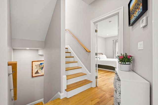 stairs featuring wood finished floors and baseboards