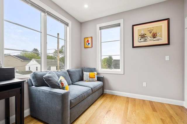 living area with baseboards, plenty of natural light, light wood-style floors, and recessed lighting