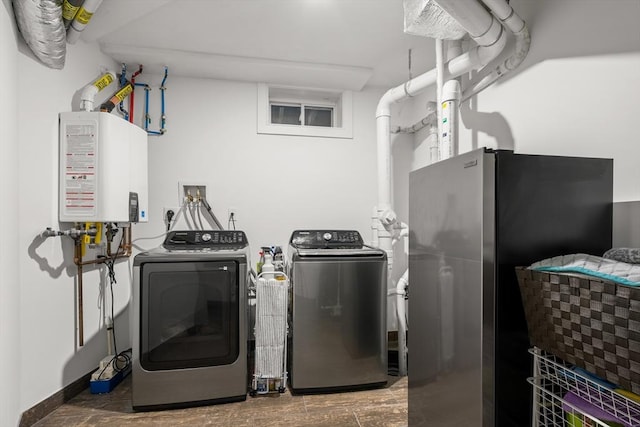 laundry room with washing machine and clothes dryer, water heater, and baseboards