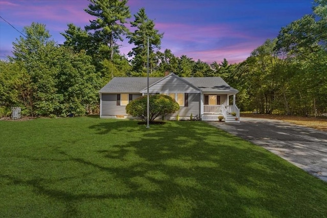 view of front of home featuring covered porch and a yard