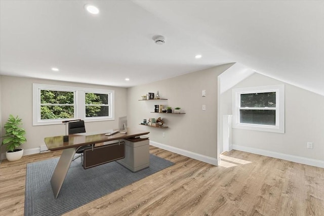 home office featuring lofted ceiling and light hardwood / wood-style flooring