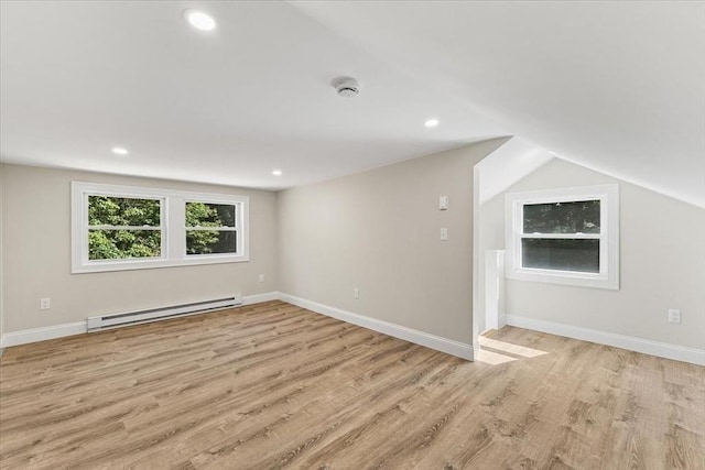 bonus room with light wood-type flooring, baseboard heating, and lofted ceiling