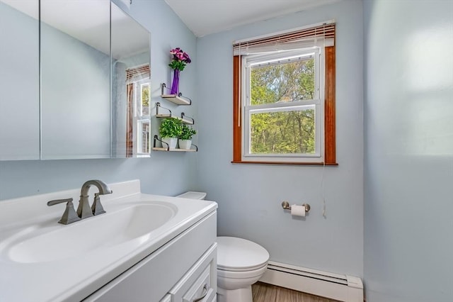 half bath with a baseboard radiator, toilet, plenty of natural light, and vanity