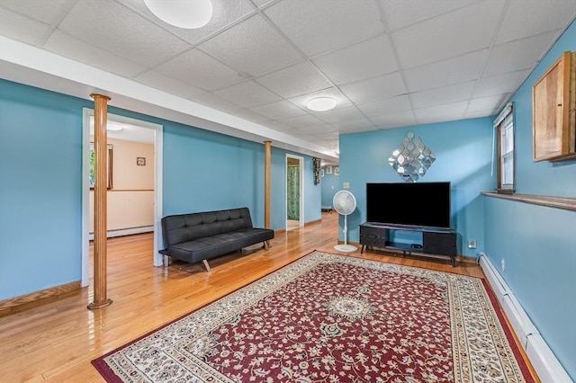 living area featuring a baseboard radiator, wood finished floors, a paneled ceiling, and baseboard heating