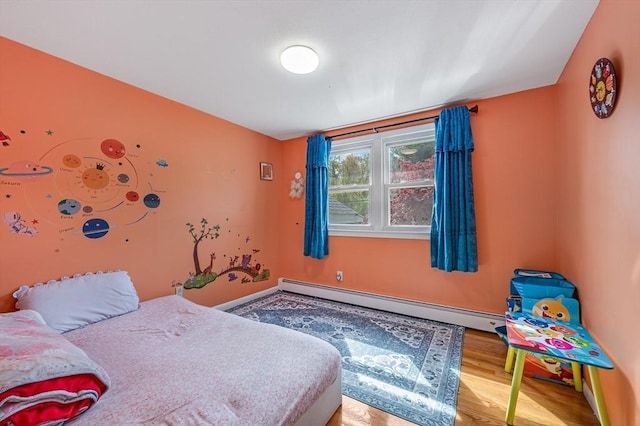 bedroom featuring baseboard heating and wood finished floors