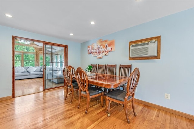 dining space with light wood finished floors, baseboards, recessed lighting, and a wall unit AC